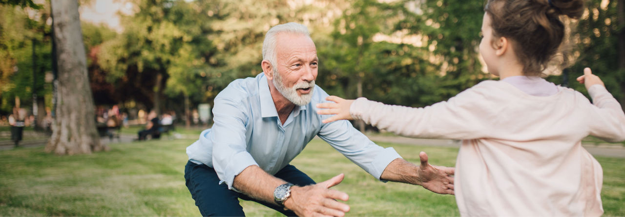 grandparent and child hugging in park