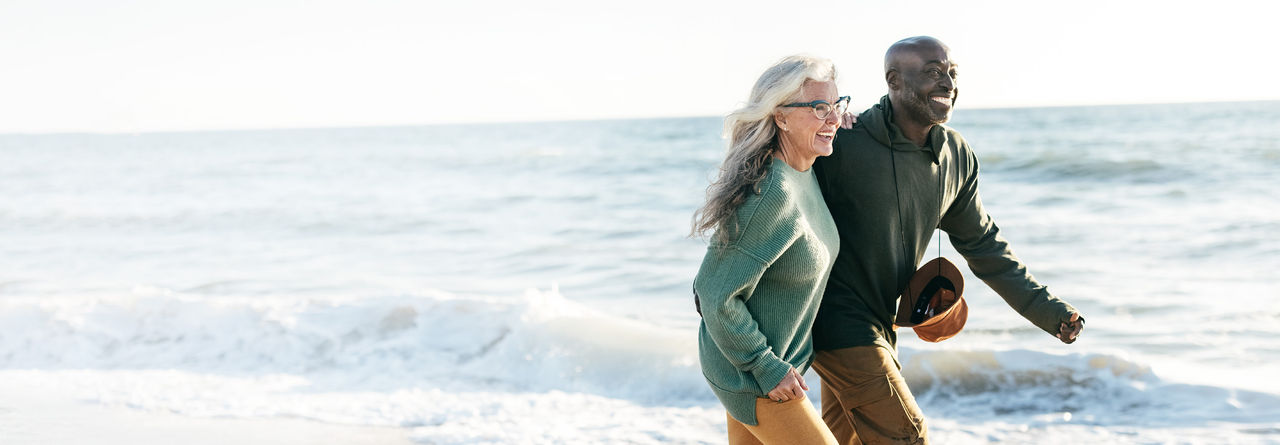 senior couple walking on beach